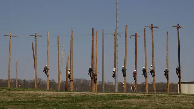 Pre-apprentice lineman class climbing telephone poles