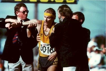 Simon Baker is helped by officials after completing the Men's Walk in Auckland